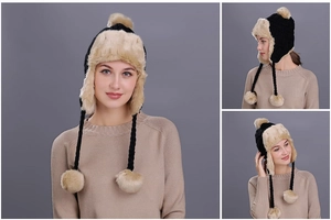 Detail of winter plaid trapper hat featuring black knit texture and khaki faux fur pom-poms