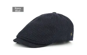 Detailed texture of navy blue corduroy cap with a bronze metallic logo on the side