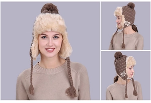 Detail view of brown winter trapper hat featuring white snowflake patterns and plush lining