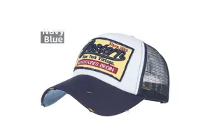 Detail of distressed navy and white trucker hat featuring vintage yellow embroidery