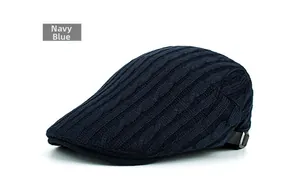 Detail of navy blue cable knit newsboy cap with metal side buckle and texture