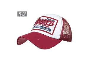 Close-up of wine red vintage trucker hat featuring patch embroidery and distressed details