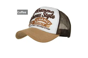 Detailed close-up of brown and white trucker hat featuring 3D letter embroidery and mesh