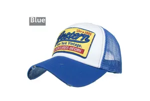 Detail of blue distressed trucker cap with vintage embroidered patch and mesh back