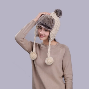 Women's knit trapper hat with cable pattern and faux fur trim for winter warmth