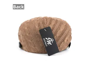 Detail view of the back of a brown cable knit newsboy cap with adjustable side buckle