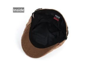 Detail view of the knitted cable peak cap showing camel outer fabric and black lining