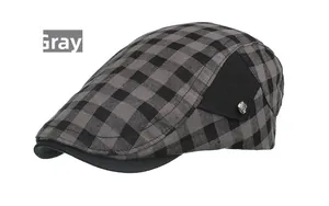 Détail d'une casquette gavroche grise à carreaux avec panneau noir et bouton en métal