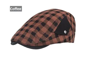 Détail de la casquette plate à carreaux marron avec bouton argenté décoratif et empiècement