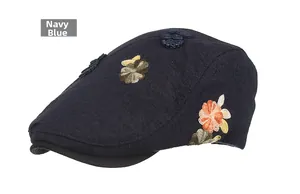 Detailed embroidery on navy blue newsboy cap featuring 3D floral patterns and buttons