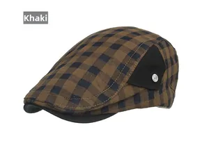 Détail de la casquette plate rétro kaki avec motif à carreaux et bouton métallique décoratif