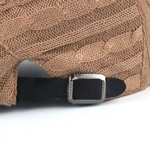 Brown cable-knit baseball cap with adjustable leather strap and silver buckle detail