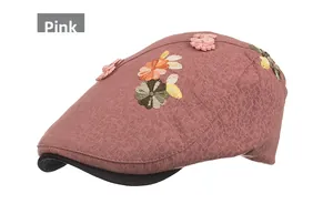 Detail of pink embroidered newsboy cap featuring black brim and colorful 3D floral textures
