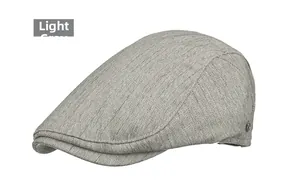 Close-up of light grey newsboy hat with herringbone texture and round metal logo