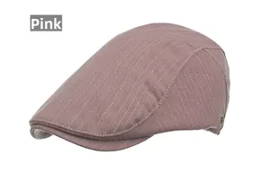 Detail of dusty pink newsboy cap with herringbone pattern and metal logo emblem