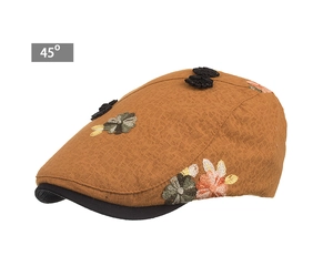 Detail showing vintage brown newsboy cap with textured grid fabric and floral embroidery