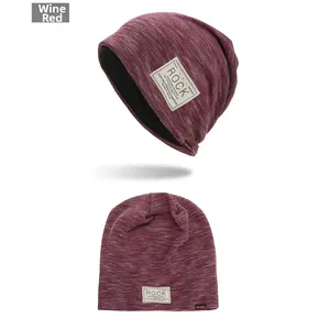 Detail view of wine red knit beanie with ROCK patch and orange sport label tag