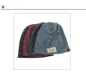 Detail view of slouchy knit beanies in four colors with retro Rock cloth labels