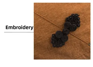 Detail of vintage brown textured fabric with exquisite black embroidery and handwork