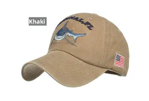 Detailed close-up of khaki cotton baseball cap featuring shark embroidery and flag patch