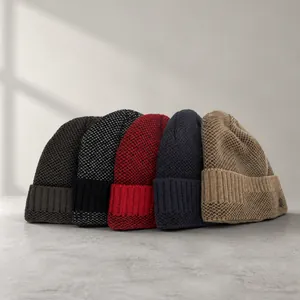 Détail de cinq bonnets en maille épaisse de couleurs assorties avec bord replié