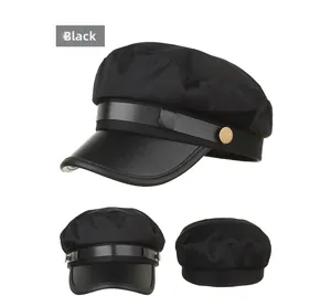 Detail view of black baker boy cap with faux leather brim and metallic side buttons