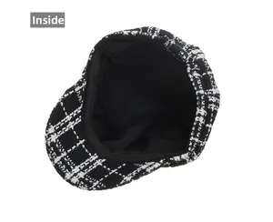 Detail view of black and white plaid newsboy cap with soft fabric lining and inner texture