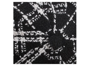 Close-up of black and white plaid tweed beret showing woven texture and top button detail