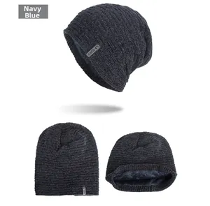 Detailed view of navy blue knit beanie with gray fleece lining and stitched logo patch
