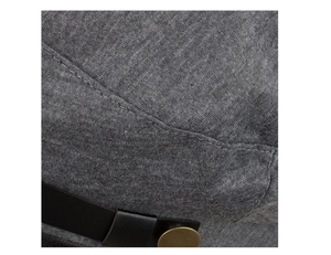 Macro detail of dark grey knitted beret with black leather strap and gold metal button