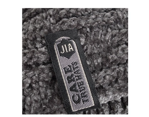 Macro detail of dark grey ribbed knit beanie showing brand label and soft fleece texture