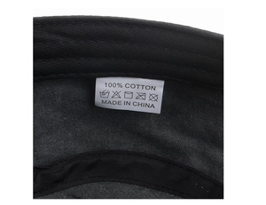 Detailed macro view of the inner 100% cotton washing label on the black cadet cap