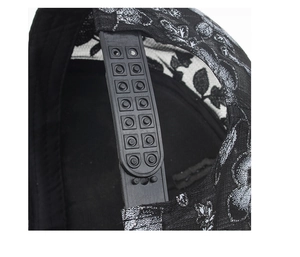 Λεπτομέρεια ρυθμιζόμενου κουμπώματος snapback σε μαύρο δαντελένιο καπέλο με λουλούδια