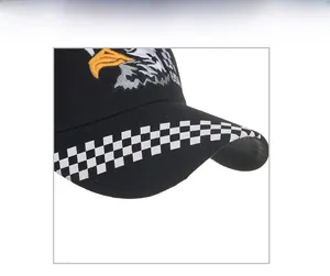Close-up of eagle embroidery and USA text on black cotton baseball cap with checkered brim