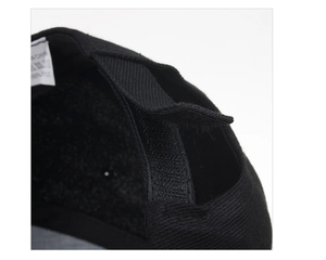 Detail of adjustable Velcro strap and 100% acrylic fabric label on black baseball cap