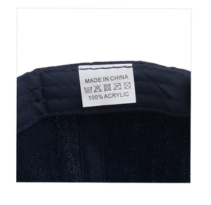 Macro detail of washing label showing 100% acrylic material on navy blue baseball cap
