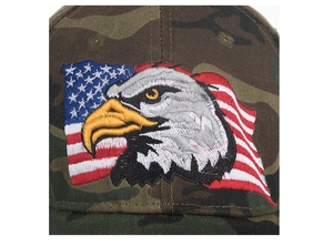 Close-up of a camouflage baseball cap featuring a detailed American flag and eagle embroidery