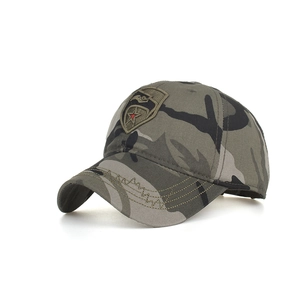 Close-up of military camouflage baseball cap with red star and bird embroidery patch