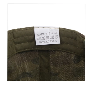 Detailed close-up of internal wash care label on camouflage baseball hat with fabric texture