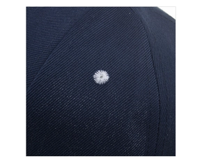 Nahaufnahme von dunkelblauem Twill-Stoff mit weißem Stickloch und präzisen Nähten