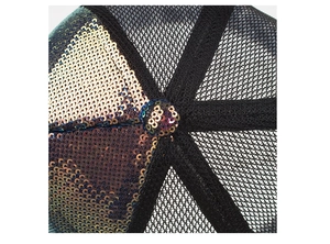 Detailed close-up of shiny iridescent sequins and black breathable mesh on a baseball cap