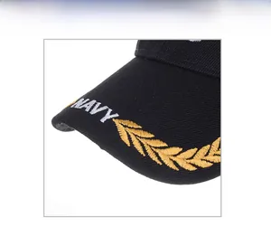 Close-up detail of Navy embroidery and golden laurel leaf patterns on black baseball cap brim