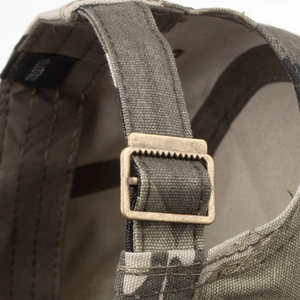 Adjustable back detail of a camouflage flat top army cap with a bronze metal buckle