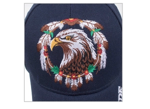 Dettaglio ravvicinato dell'intricato ricamo con testa di aquila e fiori sul cappello blu navy