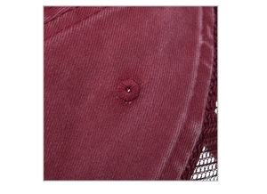 Macro shot of the dark red twill fabric, embroidered eyelet and mesh on the baseball cap