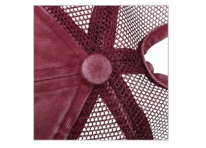 Macro detail of top button and mesh texture on dark red washed cotton trucker hat
