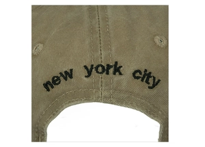 Detail view of khaki cotton baseball cap showing New York City embroidery and vent holes