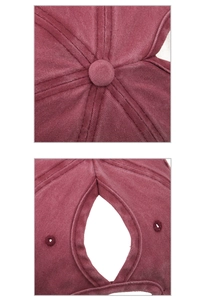 Detail view of burgundy washed baseball cap featuring ponytail hole and top button