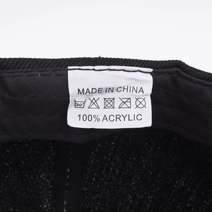Internal detail of a black baseball cap featuring 100% acrylic fabric and product care label