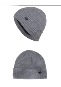 Detailansicht der grauen Strickmütze mit gummiertem Fashion-Patch für den Winter